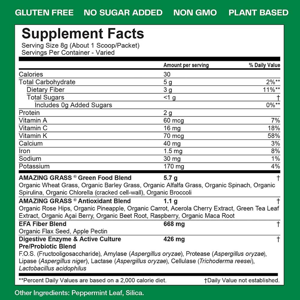 A tub of Powder Greens organic superfood powder beside a glass of the mixed drink